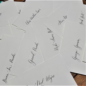 A pile of envelopes with names written in modern calligraphy