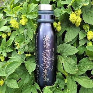 Engraved water bottle against a wall of hops plants