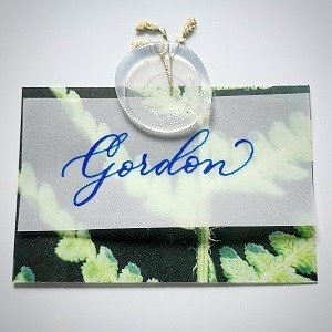 "Gordon" written in modern calligraphy on vellum paper with a floral wax seal