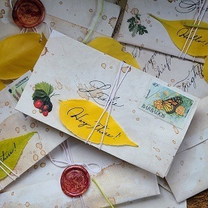 A pile of beige-colored letters sealed with a wax seal, autumn leaf, and string